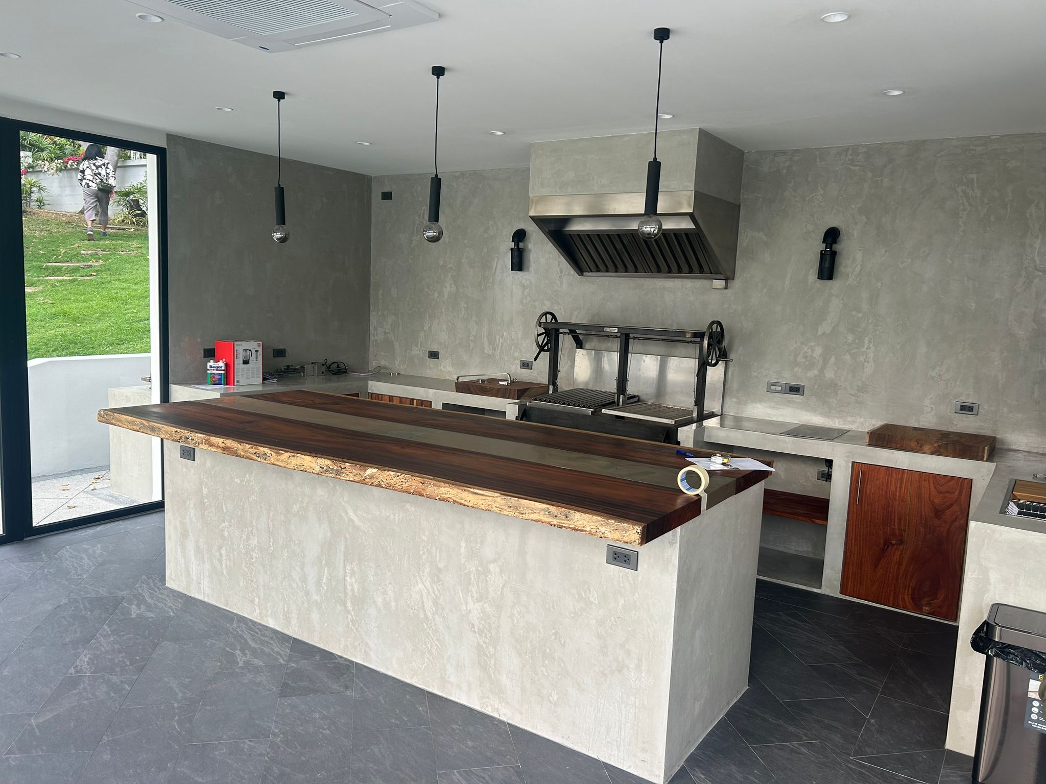 Industrial-style kitchen with concrete walls and live-edge wood countertops